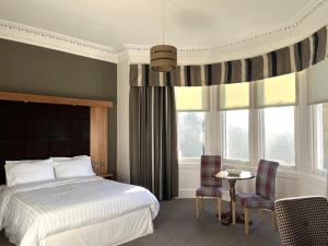 a bedroom with a bed and a table and chairs at The Strathearn Hotel in Fife +152 photos