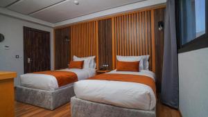 2 camas en una habitación de hotel con en Razane Hôtel en Kenitra