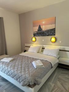 a bedroom with a large bed with a painting on the wall at Akrogiali Hotel in Agios Sostis