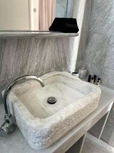a white marble sink in a bathroom at Akrogiali Hotel in Agios Sostis