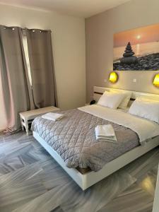 a bedroom with a large bed and a painting on the wall at Akrogiali Hotel in Agios Sostis