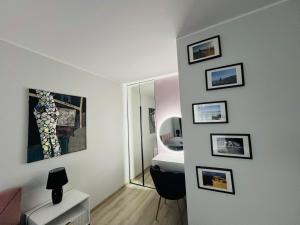 Habitación con baño con aseo y cuadros en la pared. en Apartament Ultramaryna - Reda Aquapark Lipova Park, en Reda