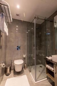 premium sea porto marina suite في العلمين: حمام مع دش زجاجي ومرحاض