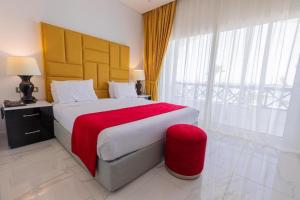premium sea porto marina suite في العلمين: غرفة نوم بسرير كبير مع بطانية حمراء