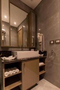 premium sea porto marina suite في العلمين: حمام مع حوض ومرآة