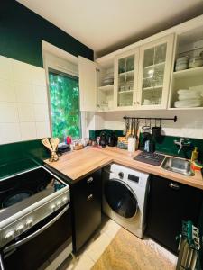 a kitchen with a washing machine and a sink at Villa Papírkutya in Veszprém +54 photos