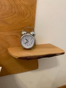 a clock on a wooden shelf on a wall at Palazzo Venieri in Lugo