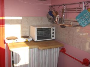 a small kitchen with a microwave on a counter at location 2-3 pers perros guirec in Perros-Guirec
