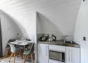 cocina con fregadero y mesa con sillas en Hillcroft Park Glamping, en Pooley Bridge