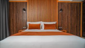 a bedroom with a large bed with two orange pillows at Razane Hôtel in Kenitra