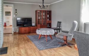 een woonkamer met een tafel en twee stoelen en een televisie bij Lovely Apartment In Sandnes With House Sea View in Forsand