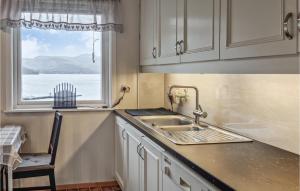 een keuken met een wastafel en een raam bij Lovely Apartment In Sandnes With House Sea View in Forsand