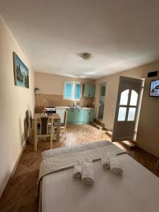 a bedroom with two beds and a table and a kitchen at Apartman Nina in Risan
