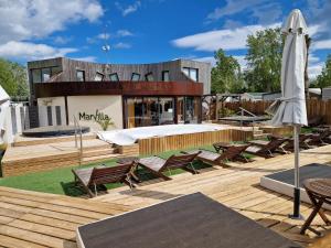 un patio con sillas, una cama y una sombrilla en Petit coin de paradis à la Yole, en Vendres