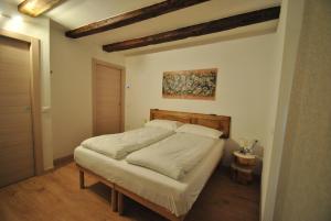 een bed in een slaapkamer met een schilderij aan de muur bij B&B alla Pieve in Calceranica al Lago
