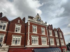 a brick building with a clock on top of it at Belvilla Crewe Arms Hotel in Crewe