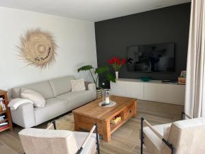 uma sala de estar com um sofá e uma mesa de centro em Logies La Parmentière em De Panne