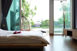 Un dormitorio con una cama con flores. en บ้านบางเตยริมน้ำพูลวิลล่า, en Ban Bang Rathuk