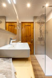 a bathroom with a white sink and a shower at Baita La Cascata in Isolaccia