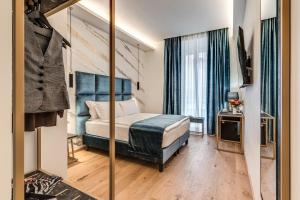 Schlafzimmer mit einem Bett und einem Spiegel in der Unterkunft Goldoni 47 in Rom
