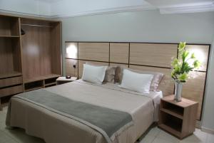a bedroom with a large bed with white pillows at Verdes Vales Lazer Hotel in Juazeiro do Norte