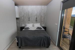 グルンダルフィヨルズルにあるDis Cottagesのベッドルーム1室(ベッド1台、大きな窓付)