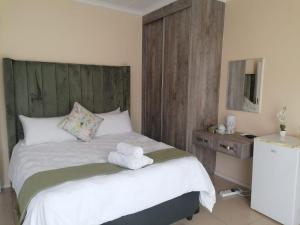 - une chambre avec un lit et 2 serviettes dans l'établissement K'S Legacy, à Kimberley