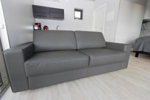 un divano grigio in un soggiorno con tavolo di Dis Cottages a Grundarfjordur