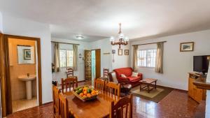 Il comprend une cuisine et un salon avec une table et des chaises. dans l'établissement Casa Victoria Alozaina by Ruralidays, à Alozaina
