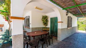 d'une terrasse avec une table et des chaises en bois. dans l'établissement Casa Victoria Alozaina by Ruralidays, à Alozaina