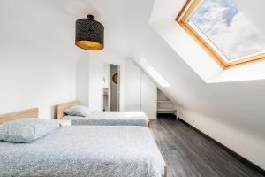 two beds in a white room with a window at Gite Ti Coz piscine intérieure in Caden +16 photos