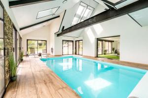 een binnenzwembad met blauw water in een huis bij Gite Ti Coz piscine intérieure in Caden