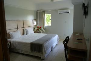 um quarto com uma cama grande e uma janela em Verdes Vales Lazer Hotel em Juazeiro do Norte