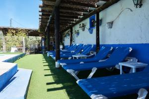 une rangée de chaises bleues assises sur le côté d'un bâtiment dans l'établissement La Sierrezuela, à Castillo de Locubín