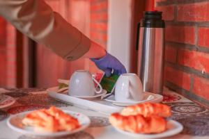 a person wearing a glove is putting food into cups at Posada Madre America in San Ignacio