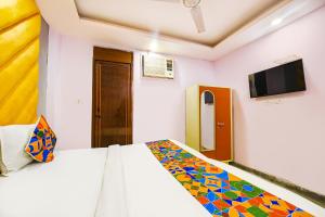 Schlafzimmer mit einem Bett und einem Flachbild-TV in der Unterkunft FabHotel Iris Lite in Neu-Delhi