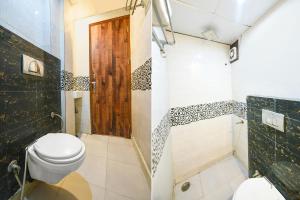 La salle de bains est pourvue d'une douche et de toilettes. dans l'établissement FabHotel Iris Lite, à New Delhi