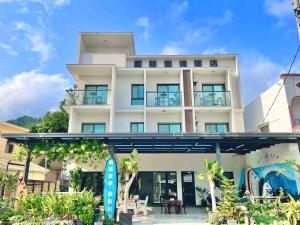 un edificio bianco con una tavola da surf di fronte di 阿郎衝浪旅店A-lang Surfing House a Manzhou