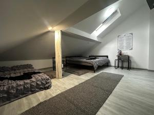a attic room with two beds and a rug at Vila Ana 2 Untold in Cluj-Napoca