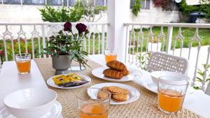 stół z talerzami jedzenia i szklanki soku pomarańczowego w obiekcie Archzante boutique villa w Kalamákion