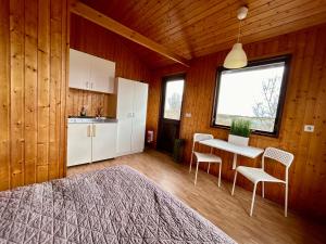 a bedroom with a bed and a table and chairs at Arhus Cottage and Camping in Hella