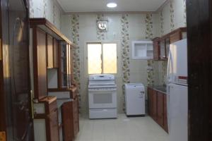 cocina con fogones y nevera y ventana en شقة خاصة للعائلات فقط en Medina