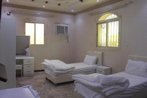 um quarto com duas camas e uma televisão e duas janelas em شقة خاصة للعائلات فقط em Medina