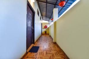 un pasillo vacío con puerta y suelo de madera en FabHotel KK Residency, en Mājra