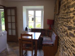 a dining room with a table and a stone wall at Au cottage normand in Saint-James +31 photos
