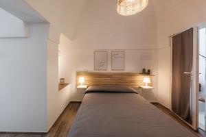 ein großes Bett in einem Schlafzimmer mit weißen Wänden in der Unterkunft Dimore Calculli - Puglia Mia Apartments in Monopoli