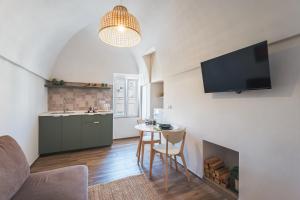 ein Wohnzimmer mit einem Tisch und einer Küche in der Unterkunft Dimore Calculli - Puglia Mia Apartments in Monopoli