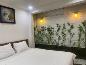 a bedroom with a bed and plants on the wall at CHILL HOME 2 in Ho Chi Minh City