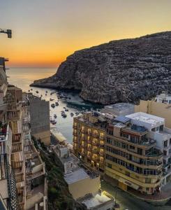 a view of a city with boats in the water at Sun Sea Living Gozo in Xlendi