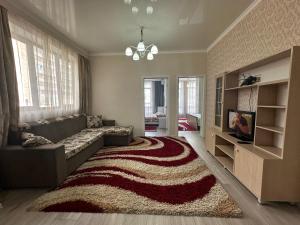a living room with a couch and a rug at 2bedroom on Diamond City in Bishkek